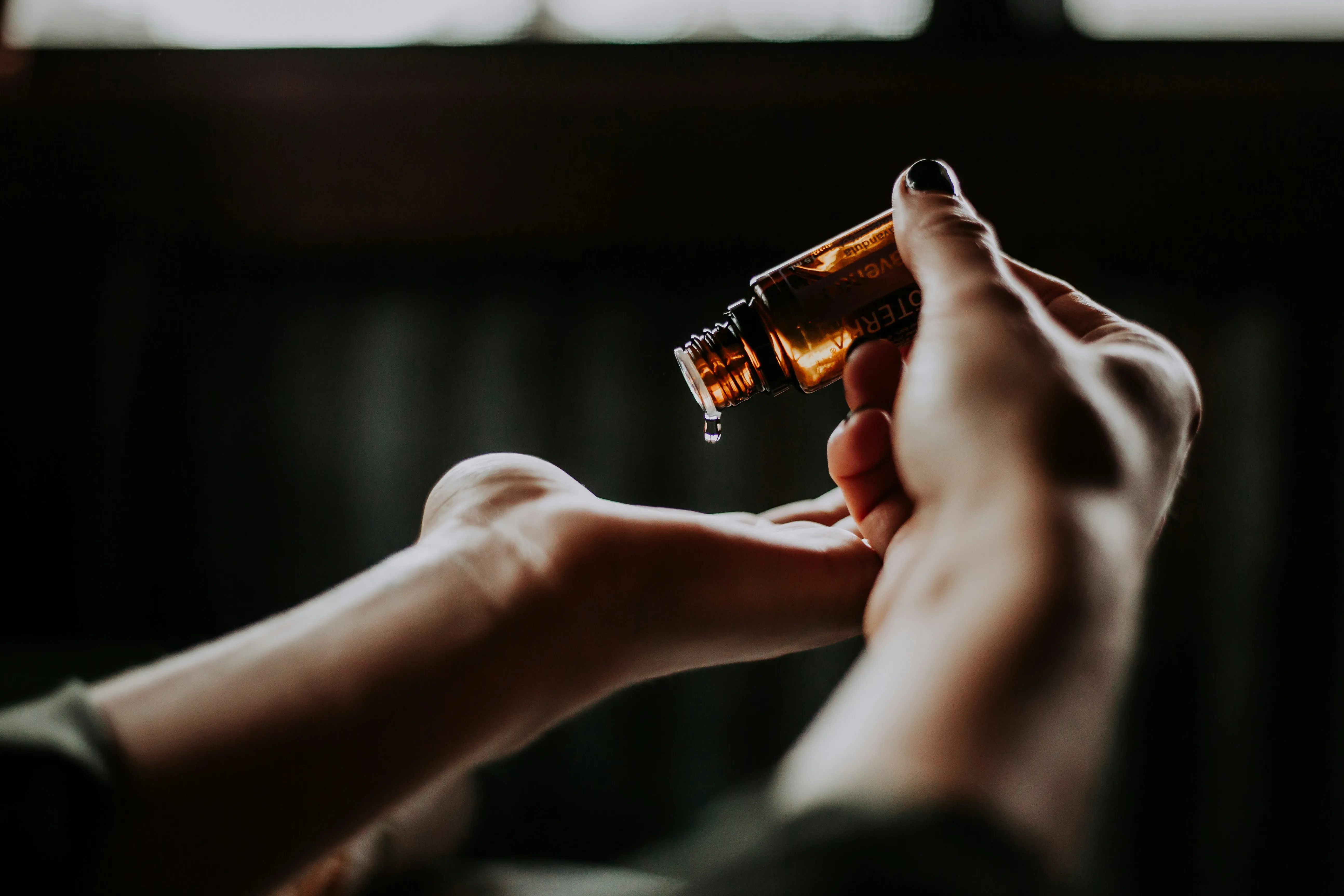 A lady applying the perfume oil on hand