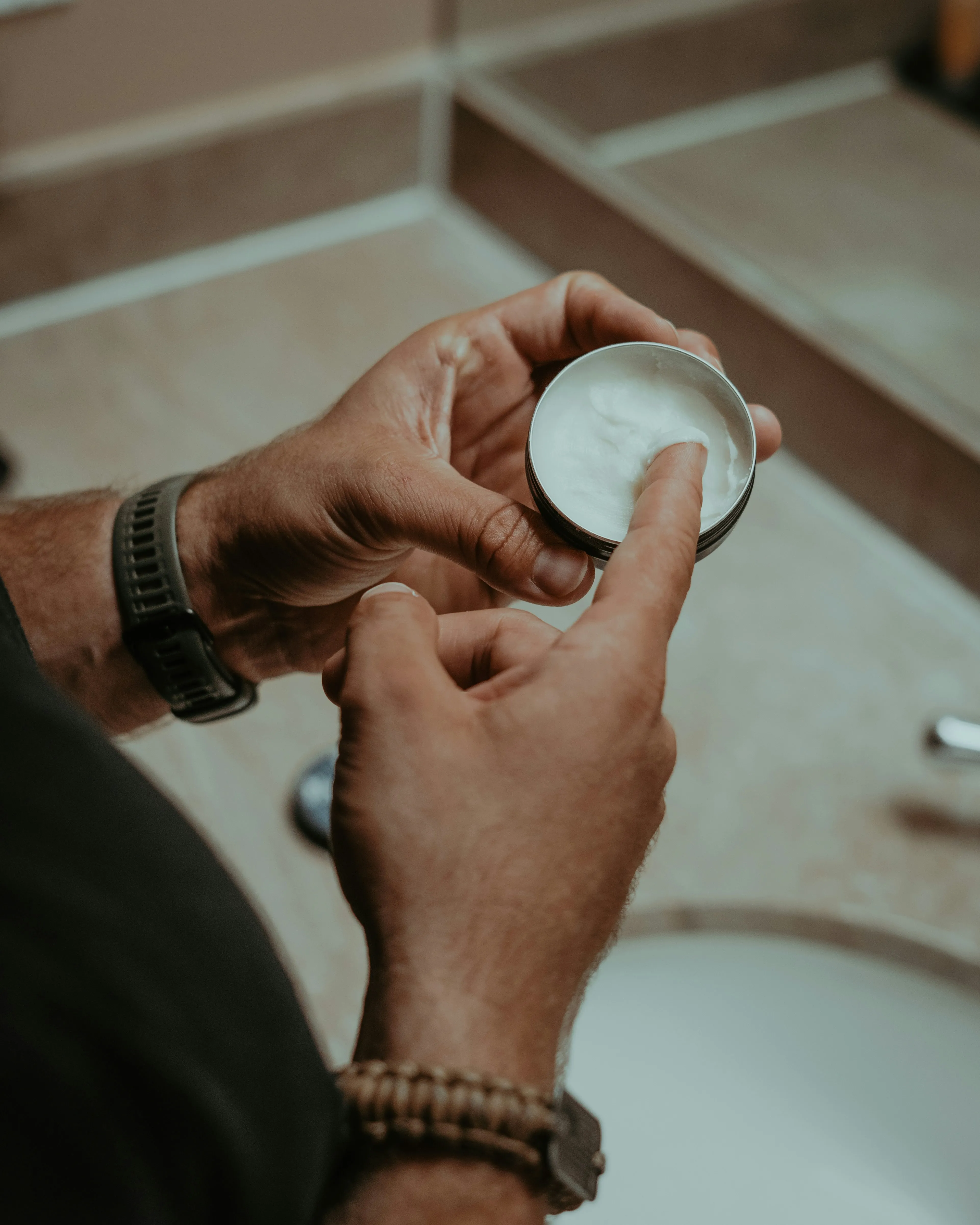 A person holding a cream container in their hands
